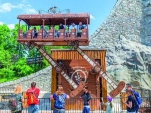 Familien fahren mit der Attraktion „Wilder Winzer“ im Familypark in einem hölzernen Wagen auf und ab.