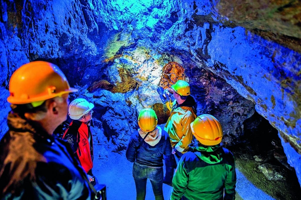 Besucher erkunden einen historischen Silberstollen im Schaubergwerk Arzberg.