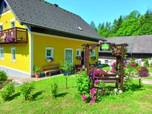Außenansicht des Schusterhans-Hofs in Semriach mit Garten und Sitzbereich.