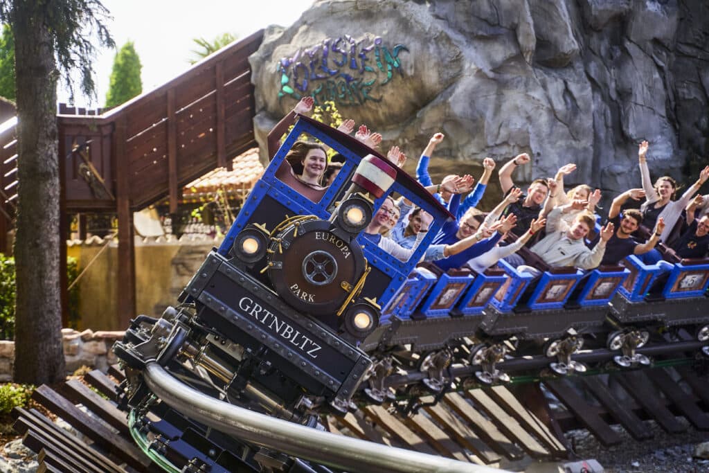 Besucher fahren mit dem Alpenexpress Enzian durch den Europa-Park.