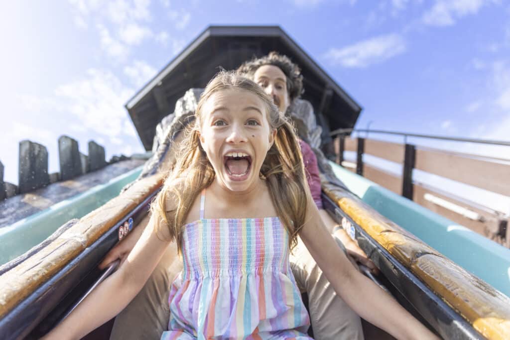 Kind fährt gemeinsam mit seiner Familie in der Tiroler Wildwasserbahn im Europa-Park.