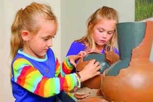 Zwei Kinder entdecken eine interaktive Keramikstation zur Hallstattzeit im Jungen Museum des KulturQuartiers Leoben.