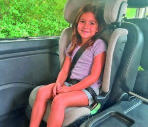 Kind sitzt angeschnallt im Thule Palm Kindersitz während des Praxistests im Familienauto.
