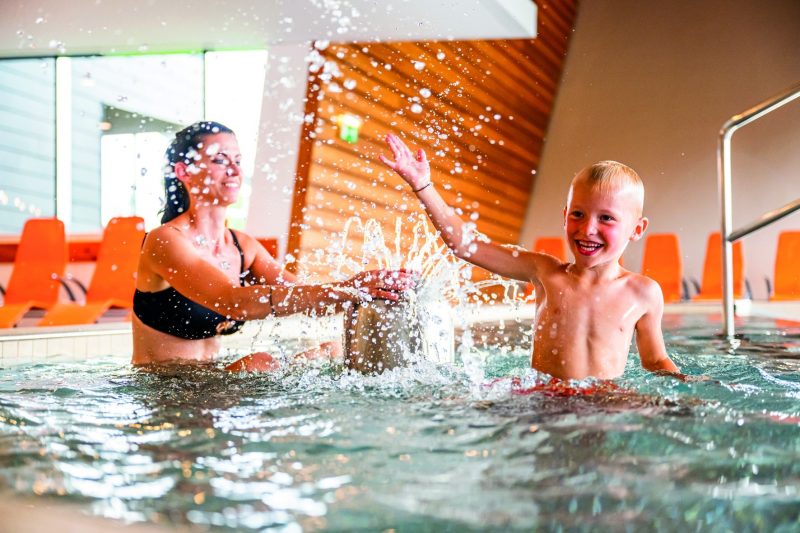 Mutter und Kind planschen gemeinsam im Thermalbecken der AQUALUX Therme Fohnsdorf.