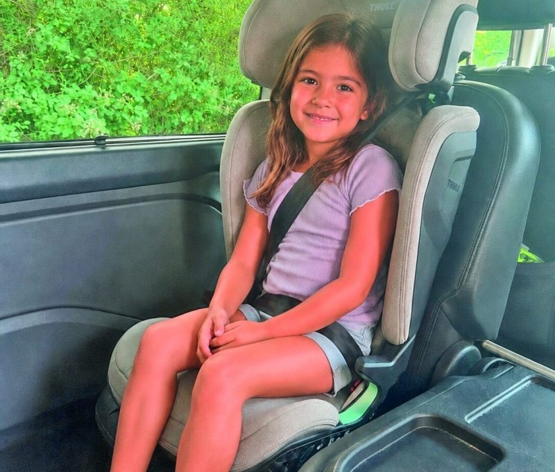 Kind sitzt angeschnallt im Thule Palm Kindersitz während des Praxistests im Familienauto.
